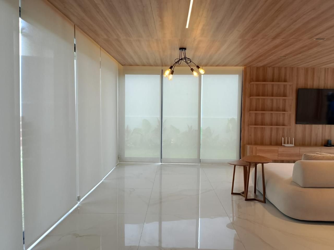 Sala ampla com persianas rolô